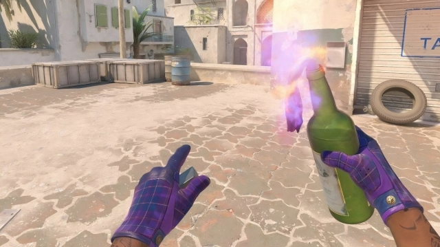 Joueur CS2 tenant une grenade Molotov sur Dust 2